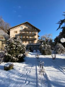 a building in the snow with two people in front at Hotel Parco Erosa in Abbadia San Salvatore