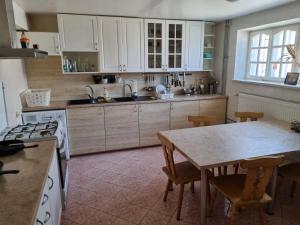 una cucina con mobili bianchi e un tavolo con sedie di LivingPalanga Meta3 a Palanga