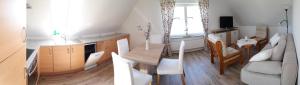 a kitchen and a living room with a table and a couch at Ferienwohnung Goden-Wind in Westerdeichstrich