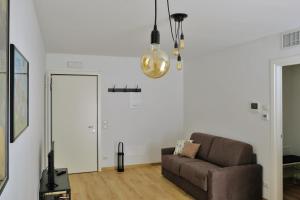 sala de estar con sofá y lámpara de araña en Appartamenti Alle 5 Torri, en Mezzolombardo