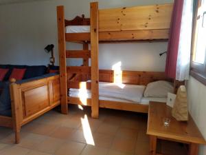 a room with two bunk beds and a table at GOOD Times Gerlitzen in Deutschberg