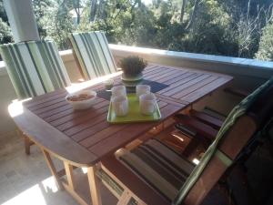 einen Holztisch mit einem Tablett mit Essen auf der Veranda in der Unterkunft Rajska idila....Silba in Silba