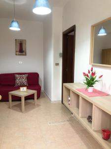 un soggiorno con un divano rosso e un tavolo di Soleado Apartments Caprioli-Palinuro a Palinuro