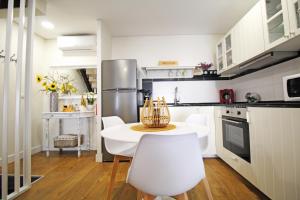 a white kitchen with a table and chairs in it at Casa do Tablado - Foz Côa in Vila Nova de Foz Coa +35 photos