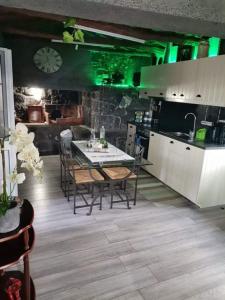 a kitchen with a table and chairs and green lights at Casinha de Pedra in Cais do Pico