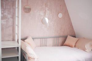 a bedroom with a bed with pink walls and pendant lights at Paradise St Apartment Top Floor 3 flights of stairs 3 bed 1 bathroom in Rhyl