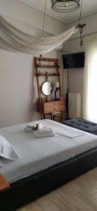 sypialnia z dużym łóżkiem i krzesłem w obiekcie Villa Tsios w mieście Artemida