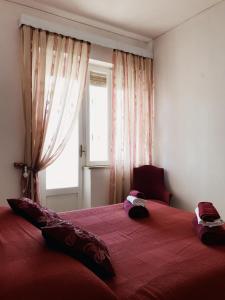 una camera da letto con un grande letto rosso e una finestra di Casa Zi' Peppe a Capranica