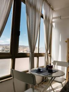 einen Tisch und Stühle in einem Zimmer mit Fenstern in der Unterkunft Casa Zi' Peppe in Capranica