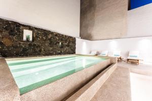 a pool in a house with a stone wall at Casa Reale in Fira +23 photos