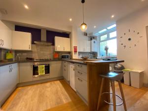 a large kitchen with white cabinets and a counter top at 77 Underwood Lane in Crewe