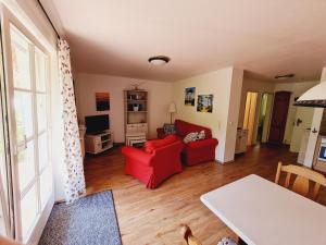 - un salon avec un canapé rouge et une télévision dans l'établissement Zingst Achtern Diek 12d Elly, à Zingst