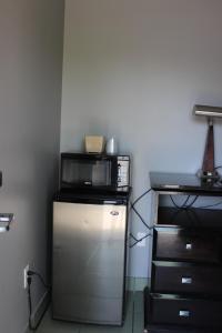 een kleine keuken met een magnetron bovenop een koelkast bij Super 7 Motel London in London