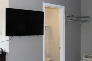 a flat screen tv on the wall of a bathroom at Super 7 Motel London in London