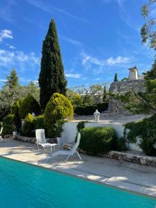 una piscina con due sedie e un albero di Pietrefitte a Ostuni