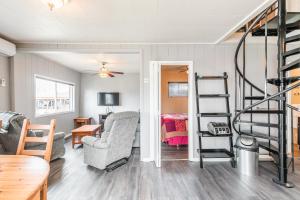a living room with a spiral staircase and a bedroom at Bayside Cottage Rentals in Port Rowan