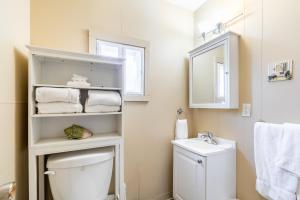a bathroom with a white toilet and a sink at Bayside Cottage Rentals in Port Rowan +76 photos