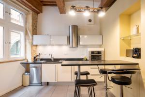 a kitchen with white cabinets and a black counter top at Honorê, Suite Saint Georges in Lyon