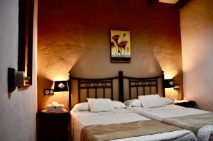 a bedroom with two beds in a room at Cortijo Mesa de la Plata in Arcos de la Frontera