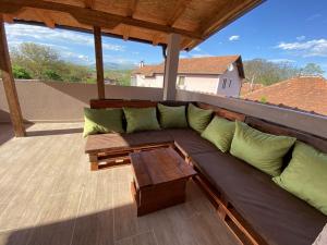 a couch sitting on a balcony with a table at Apartments Zlatko in Soko Banja