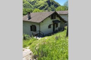 Casa Cantoni في Menzonio: منزل أبيض صغير في حقل من العشب
