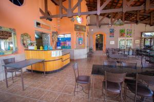 a restaurant with tables and chairs and a bar at Aldeia Parque Pousada Rural in São Roque