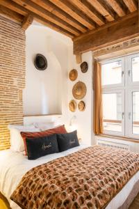 a bedroom with a large bed with a brick wall at Honorê, Suite Saint Georges in Lyon
