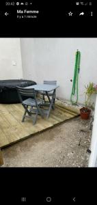 une table de pique-nique et un tuyau vert à côté d'un mur dans l'établissement Joli studio avec jacuzzi et terrasse privée, à Junas