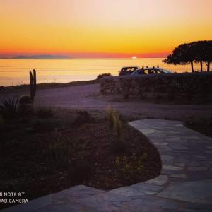 a car parked on the beach at sunset at Sunset Studios & Rooms in Antiparos