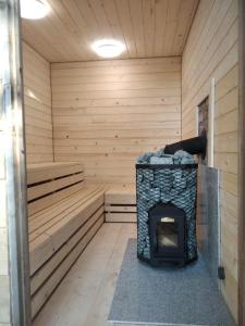 a sauna with a fireplace in the middle at Srokowski Dwór 1 - Leśny Zakątek - Prywatna Sauna! in Srokowo
