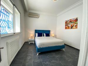 um quarto com uma cama azul e uma janela em Cosy Duplex in Sidi Bou Said em Dar Mimoun Bey