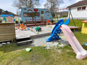 una zona de juegos con un tobogán y un parque infantil en Wathne Camping en Bjørheimsbygda