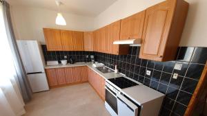 a kitchen with wooden cabinets and a white refrigerator at Apartament Miarki 3 in Świnoujście