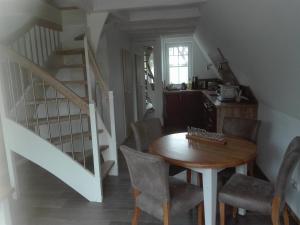 a dining room with a table and a staircase at Finnhütte Bernstein in Gager