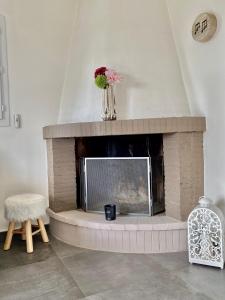 a fireplace with a vase of flowers on top of it at Le Bellevue in Saint-Paul-de-Vence