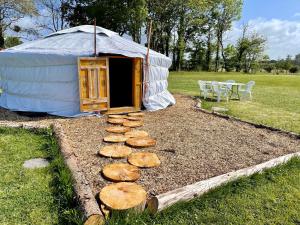 a yurt with a table and chairs in a field at Les Logis de Kerdrien in Guidel-Plage