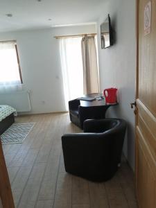 a living room with two black chairs and a table at Cazare REGIM HÔTELIER ZĂRNEŞTI in Zărneşti