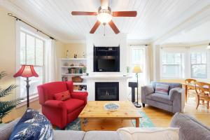 a living room with a fireplace and a ceiling fan at Looney Dunes in Lincoln City