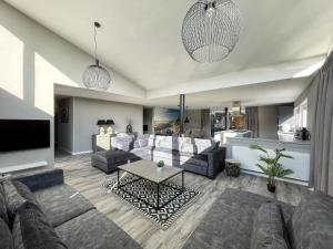 uma sala de estar com um sofá e uma mesa em Maison Jolie em Sint-Annaland