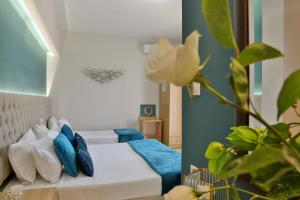sypialnia z łóżkiem z niebiesko-białymi poduszkami w obiekcie Irida Apartments w mieście Leptokaria