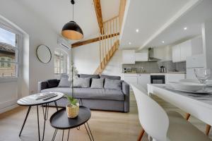 a living room with a couch and a table at Confortable Rooftop view Appart Hôtel Avignon in Avignon