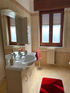 uma casa de banho com um lavatório e um espelho grande em Ciccio apartment em Bovalino Marina