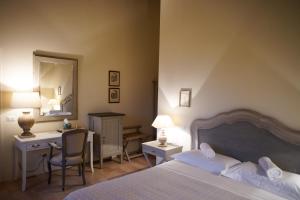 een slaapkamer met een bed, een bureau en een spiegel bij Parco di Montebello in Quattro Castella