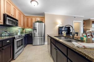 a kitchen with wooden cabinets and a stainless steel refrigerator at Lake Chatuge Retreat in Hiawassee