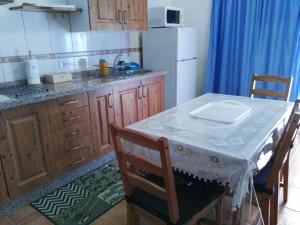a kitchen with a table and a white refrigerator at Apartamentos el Motor Tejeda in Tejeda