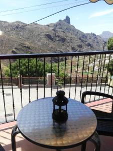 a table on a balcony with a view of a mountain at Apartamentos el Motor Tejeda in Tejeda