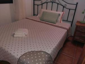 a bed with a polka dot blanket and a chair at Apartamentos el Motor Tejeda in Tejeda