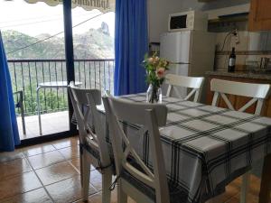 a dining room table and chairs with a view of a balcony at Apartamentos el Motor Tejeda in Tejeda