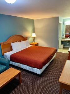a hotel room with a large bed and a blue couch at Plaza Inn Springfield in Springfield