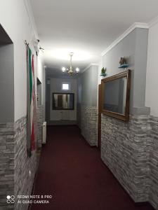 a hallway with a brick wall and a flat screen tv at Hostel Los Amigos in Rzeszów